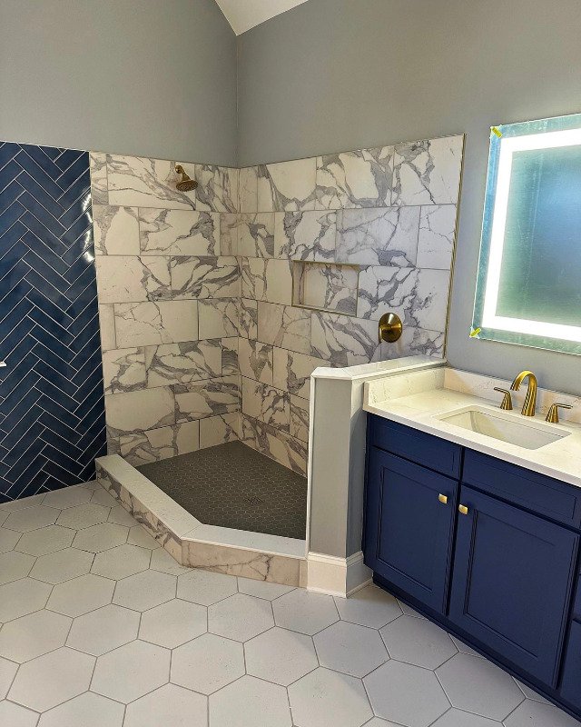 A bath remodel in Bailey's Crossroads, VA showing a large walk-in shower with white and gray marble tile walls.